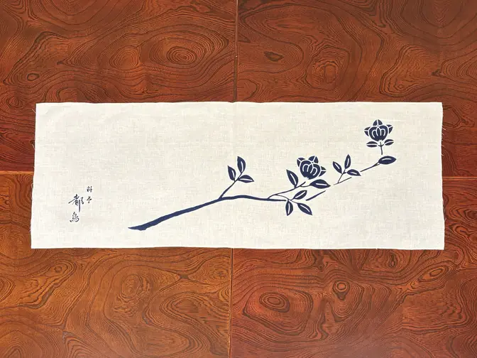 A hand towel dyed with an indigo camellia branch